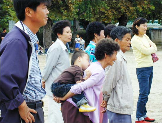 "고 녀석들 잘 하네~" 사물놀이 공연을 지켜보는 마을주민들의 시선이 사뭇 진지하다. 할머니의 등에 업힌 어린이는 잠이 들고 말았다. 